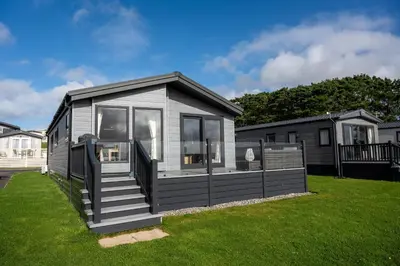a small house on the grass in a yard at Luxury 3 bedroom Maple View Lodge, Newquay, Cornwall in Newquay