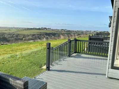 a balcony of a house with a view of a field at Luxury 3 bedroom Maple View Lodge, Newquay, Cornwall in Newquay