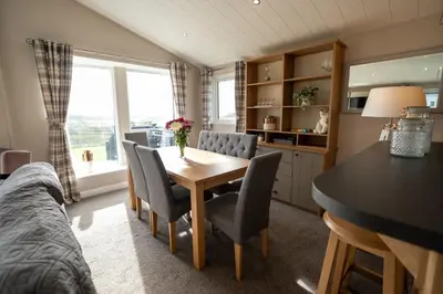 a kitchen and dining room with a table and chairs at Luxury 3 bedroom Maple View Lodge, Newquay, Cornwall in Newquay