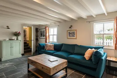 a living room with a blue couch and a table at White House Cottage, Port Isaac Bay Holidays in Port Isaac