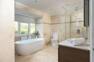 a bathroom with a tub and a toilet and a sink at Chy an Mor in Coverack