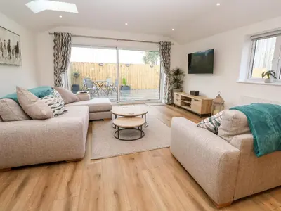 a living room with two couches and a table at Puffins Rest in Penzance