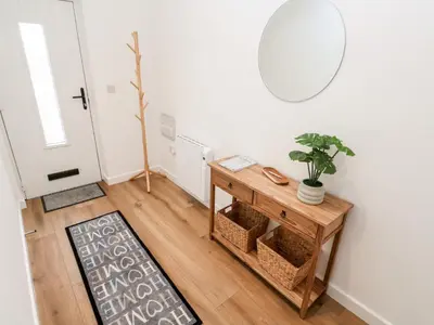 a living room with a table and a mirror at Puffins Rest in Penzance