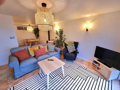 a living room with a blue couch and a table at 1Rosemount -Marazion - Iconic view of St Michaels Mt, Sea, Beach, 2xParking, Netflix Prime in Marazion