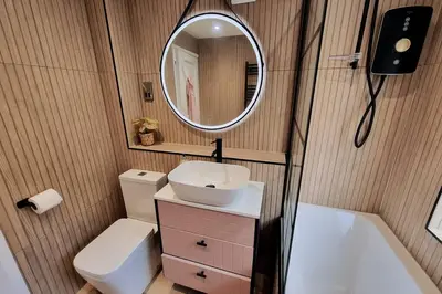 a bathroom with a sink and a mirror and a toilet at 1Rosemount -Marazion - Iconic view of St Michaels Mt, Sea, Beach, 2xParking, Netflix Prime in Marazion