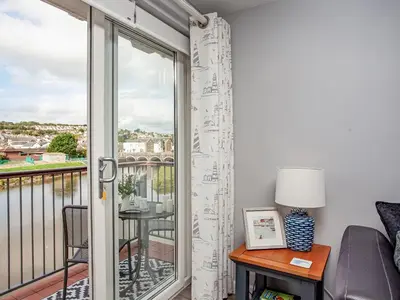 a living room with a balcony with a sliding glass door at 6 Camelside in Wadebridge