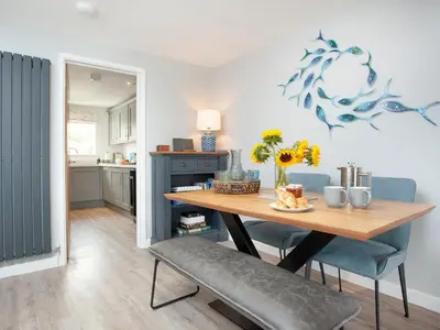 a kitchen and dining room with a table and chairs at 6 Camelside in Wadebridge
