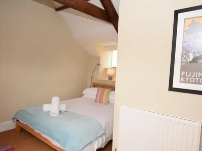 a small bedroom with a bed and a chair at 4 Bed in Tintagel oc-tolbo in Tintagel