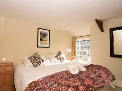 a bedroom with a large white bed and a window at 4 Bed in Tintagel oc-tolbo in Tintagel