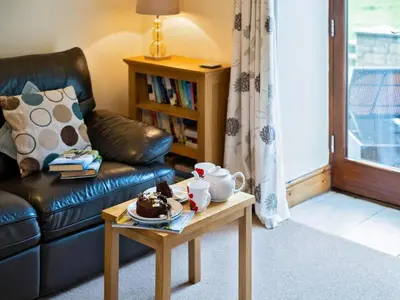 a living room with a couch and a table with cake on it at 3 Bed in Helston oc-htfox in Saint Martin