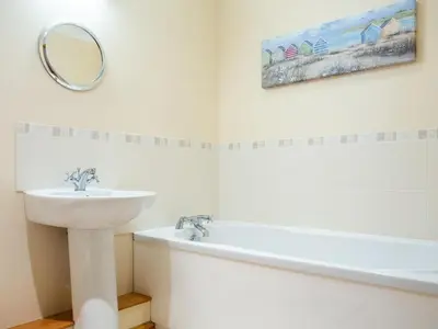 a bathroom with a sink and a tub and a mirror at 3 Bed in Helston oc-htfox in Saint Martin