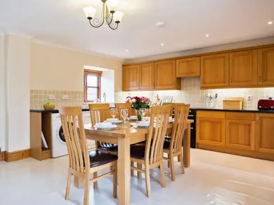 a kitchen with a wooden table and wooden cabinets at 3 Bed in Helston oc-htfox in Saint Martin