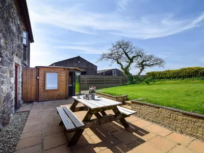 a picnic table and bench on a brick patio at 3 Bed in Helston oc-htfox in Saint Martin