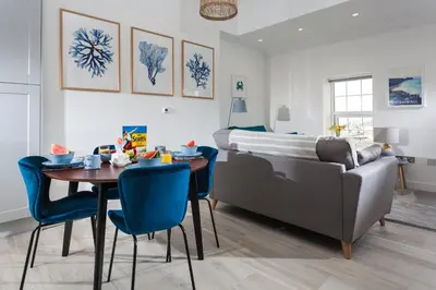 a living room with a dining room table and a couch at Chy Lowen in Helston