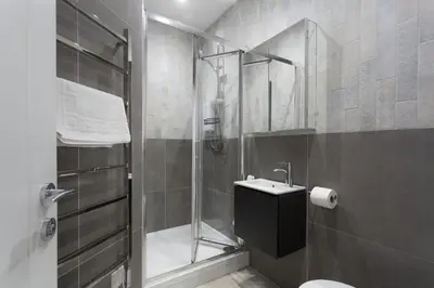a bathroom with a shower and a toilet and a sink at Chy Lowen in Helston