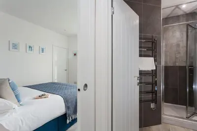 a small bedroom with a bed and a shower at Chy Lowen in Helston