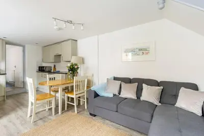 a living room with a gray couch and a table at Stunning cosy cottage in old town Padstow sleeps 4 in Padstow