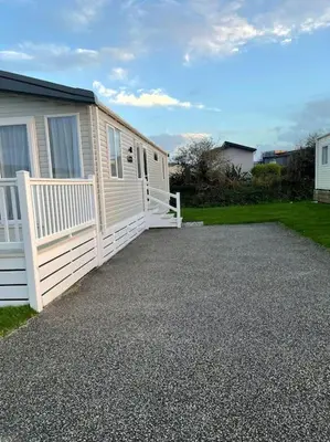 a house with a white fence and a driveway at Two bedroom Holiday home in Newquay