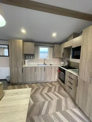 a large kitchen with wooden cabinets and a sink at Two bedroom Holiday home in Newquay