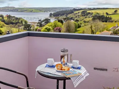 a table with a plate of donuts on a balcony at 3 Bed in Truro oc-81488 in Saint Just in Roseland