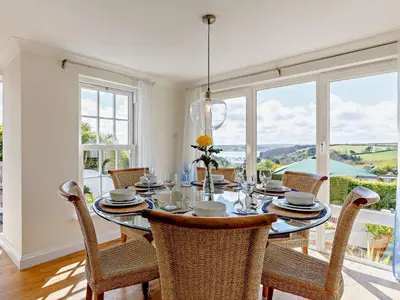 a dining room with a table and chairs and windows at 3 Bed in Truro oc-81488 in Saint Just in Roseland
