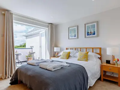 a bedroom with a bed and a large window at 3 Bed in Truro oc-81488 in Saint Just in Roseland