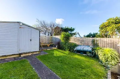 a backyard with a fence and a yard withgrass at Tre Lowen in Port Isaac