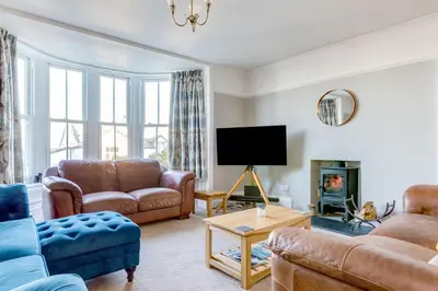 a living room with leather furniture and a tv at Tre Lowen in Port Isaac