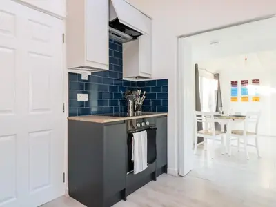 a kitchen with a stove and blue tiles at Little Seacroft in Newquay
