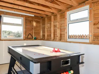 a stove top in a kitchen with two windows at Little Seacroft in Newquay