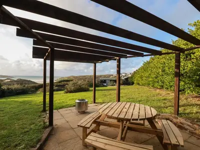 a picnic table and a bench on a patio at Little Seacroft in Newquay