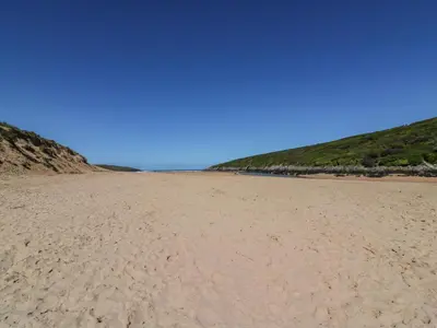 a sandy beach with footprints in the sand at Little Seacroft in Newquay