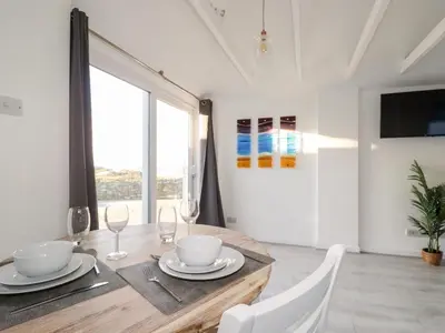 a dining room with a table and chairs and a window at Little Seacroft in Newquay