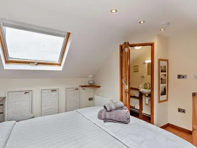 a bedroom with a large white bed with a window at 3 Bed in Truro oc-78090 in Porthtowan