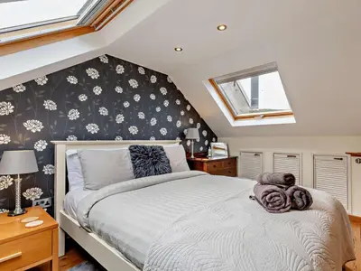 a bedroom with a bed with a flower patterned wall at 3 Bed in Truro oc-78090 in Porthtowan