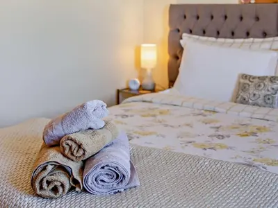 a pile of towels sitting on top of a bed at 3 Bed in Truro oc-78090 in Porthtowan