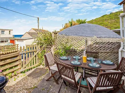 a patio with a table and chairs with an umbrella at 3 Bed in Truro oc-78090 in Porthtowan