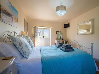a bedroom with a bed with blue sheets and a window at 2 Bed in Camelford oc-81245 in Camelford