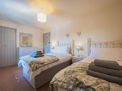 a bedroom with two beds and a dresser at 2 Bed in Camelford oc-81245 in Camelford