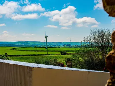 a view of a green field with wind turbines at 2 Bed in Camelford oc-81245 in Camelford