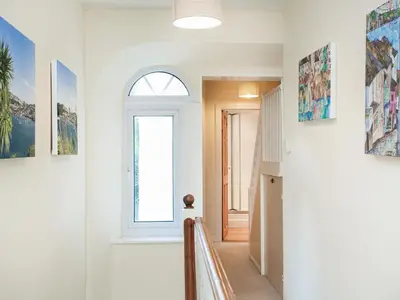 a hallway with a window and paintings on the walls at Tean in Polruan