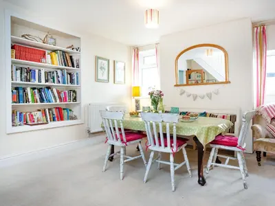 a dining room with a table and chairs and bookshelves at Tean in Polruan