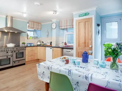 a kitchen with a table with a table cloth on it at Tean in Polruan