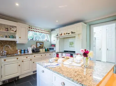 a kitchen with white cabinets and a marble counter top at 4 Bed in Truro oc-75546 in Ladock