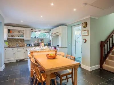 a kitchen with a wooden table and a dining room at 4 Bed in Truro oc-75546 in Ladock