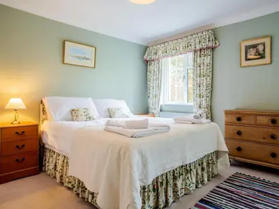 a bedroom with a bed with white sheets and a window at 4 Bed in Truro oc-75546 in Ladock