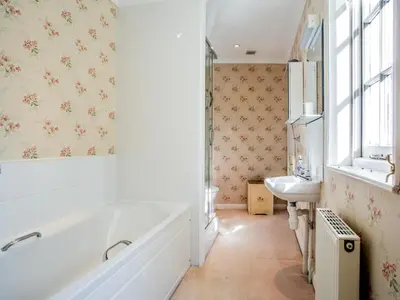 a white bathroom with a tub and a sink at 4 Bed in Truro oc-75546 in Ladock