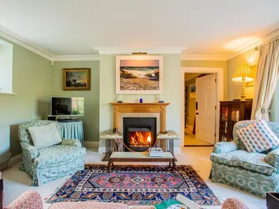 a living room with two chairs and a fireplace at 4 Bed in Truro oc-75546 in Ladock