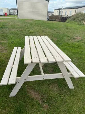 a white picnic table sitting on the grass at Perranporth Beach 3 Bed Holiday Home Cornwall. in Perranporth
