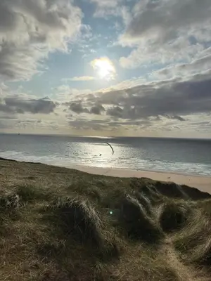a beach with the ocean on a cloudy day at Perranporth Beach 3 Bed Holiday Home Cornwall. in Perranporth